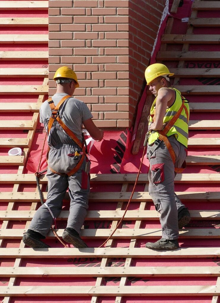 two roofers on wood pallets before winter roofing season approaches