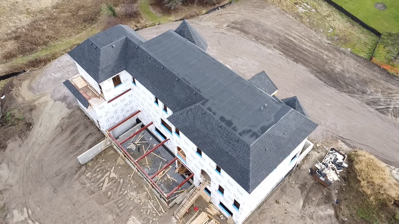 Aerial view of a completed shingle roof on a large new home
