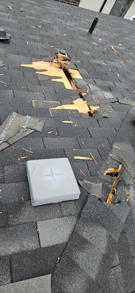 Lightning strike damage to asphalt shingle roof — shingles blown off, plywood decking split — Pickering, ON