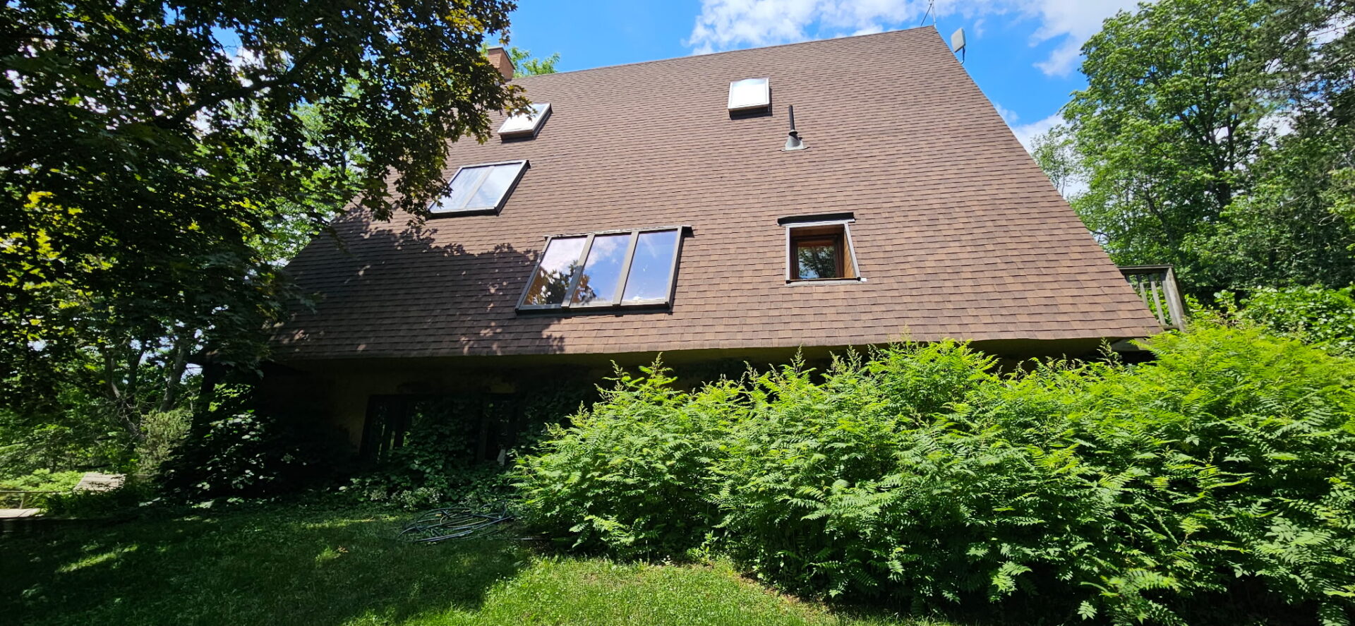Newly replaced skylights and flashing on the steep shingle roof of a Claremont cottage
