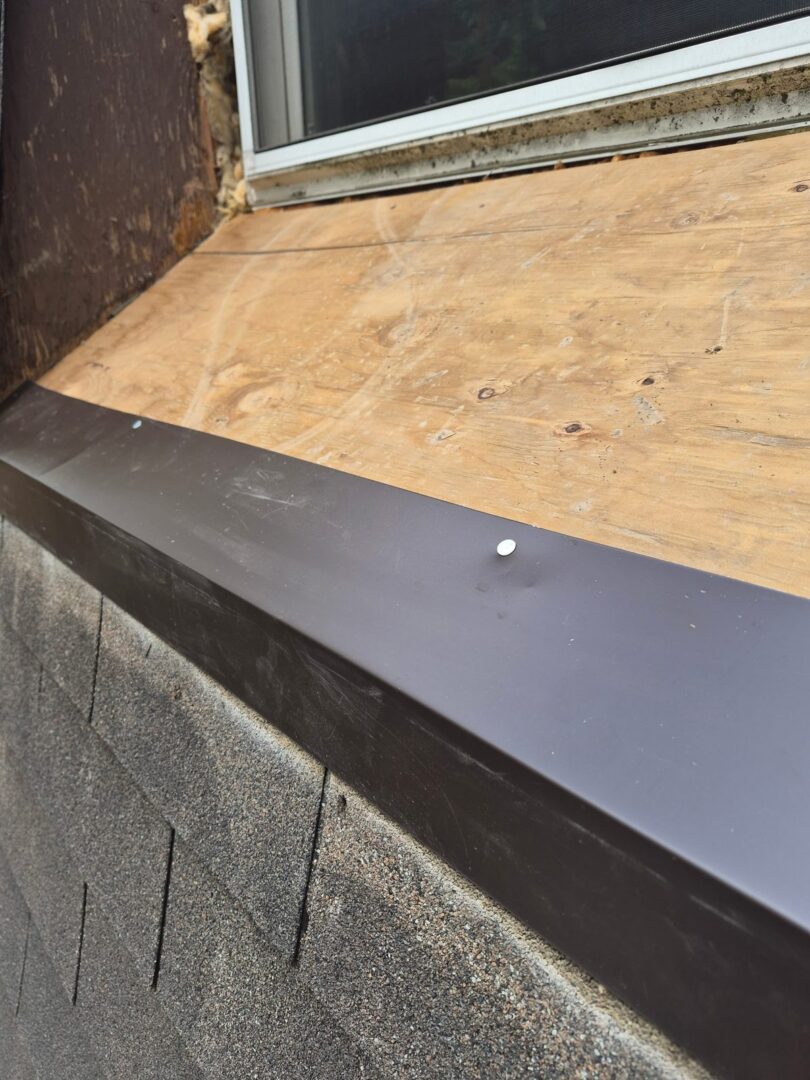 New plywood sheathing and sheet metal flashing under a roof window in Ajax