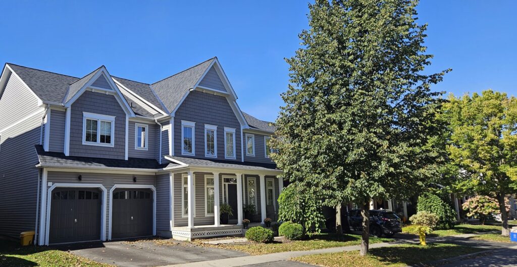 Brooklin two-storey with new 2-Tone Black shingles over the main roof, garage and covered front porch